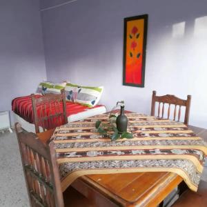 a dining room with a table and two beds at Hospedaje el Abuelo in Humahuaca