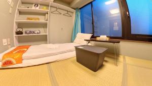 東京的住宿－無料wi-fi JING HOUSE 秋葉原 電動自転車レンタル，客房设有床、书桌和窗户。