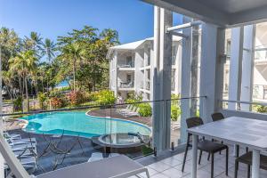 a balcony with a swimming pool and a table and chairs at Beaches Holiday Apartments - Official Onsite Reception & Check In in Port Douglas +2 photos