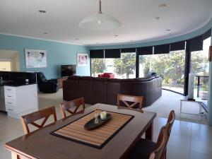 a living room with a table and a couch at Heyfield Motel and Apartments in Lakes Entrance