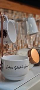 a white coffee cup sitting on top of a counter at Cabana Drechsler Gramado in Gramado