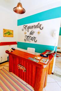 a desk in a room with a sign on the wall at Pousada Aquarela do Mar in Abraão