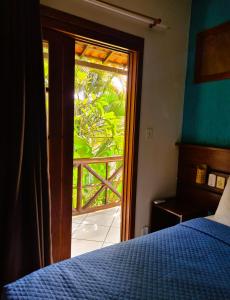 イーリャ・グランデにあるPousada Aquarela do Marのベッドルーム1室(ベッド1台付)、スライド式ガラスドアが備わります。