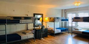 a room with three bunk beds and a mirror at Melrose Hostel in Los Angeles