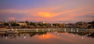 un pequeño barco en un cuerpo de agua al atardecer en Pachamac House, en Guayaquil