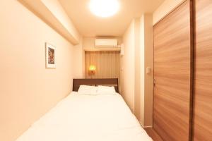 a small bedroom with a bed and a wooden door at HIZ HOTEL - Vacation STAY 08964v in Tokyo