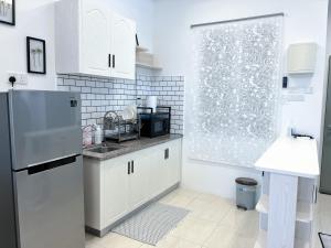 a kitchen with a sink and a refrigerator at Ins Apartment Langkawi Simfoni Beliza KUAH in Kuah