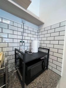 a black table in a room with a white brick wall at Ins Apartment Langkawi Simfoni Beliza KUAH in Kuah