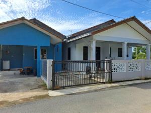 a blue and white house with a fence at Avohomestay YouTube Netflix in Kuala Terengganu