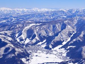 an aerial view of a snowy mountain range at Minshuku Kojima in Nozawa Onsen