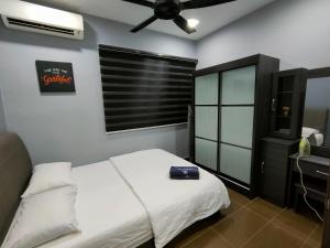 Three-Bedroom House at Tyara Homestay Sunway في بيتالينغ جايا: غرفة نوم بسرير ومكتب ونافذة