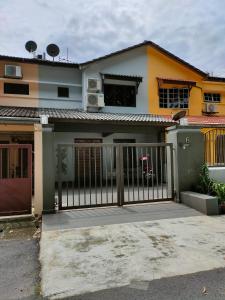 uma casa com um portão em frente em Three-Bedroom House at Tyara Homestay Sunway em Petaling Jaya