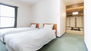 Postel nebo postele na pokoji v ubytování Hotel & Onsen 2307 Shigakogen