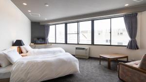 um quarto de hotel com duas camas e uma janela em Hotel & Onsen 2307 Shigakogen em Yamanouchi