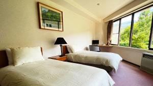 Postel nebo postele na pokoji v ubytování Hotel & Onsen 2307 Shigakogen