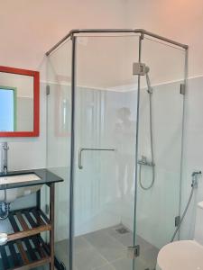 a shower with a glass door in a bathroom at Chành Rành House in Vĩnh Hy