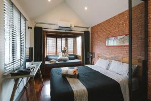 a bedroom with a bed and a brick wall at Ruanmata Homestay in Chiang Mai