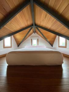 a large bed in a room with a wooden ceiling at Tiny House, La Candelaria in Luján +8 photos