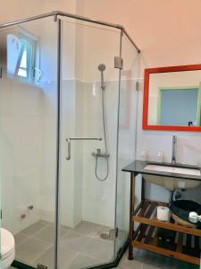 a glass shower in a bathroom with a sink at Chành Rành House in Vĩnh Hy