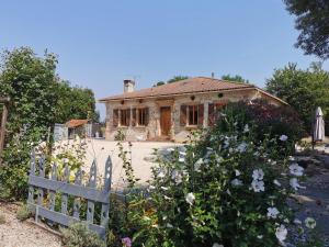 a house with a fence and flowers in front of it at LA VIE EST BELLE 