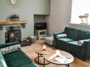 Dove Cottage-number 16 في بلفورد: غرفة معيشة بها كنبتين خضراء وطاولة