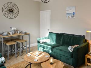 Dove Cottage-number 16 في بلفورد: غرفة معيشة مع أريكة خضراء وطاولة