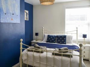 Dove Cottage-number 16 في بلفورد: غرفة نوم مع سرير والجدران الزرقاء