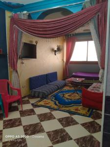 ein Wohnzimmer mit einem Sofa und einem Bett in der Unterkunft الضيافة in Shakshuk
