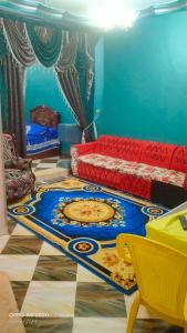 ein Wohnzimmer mit einem Sofa und einem Teppich auf dem Boden in der Unterkunft الضيافة in Shakshuk