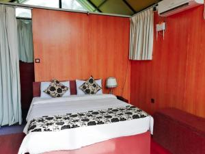 a bedroom with a bed in a red wall at Kolonne RIverside Garden Hotel in Avissawella
