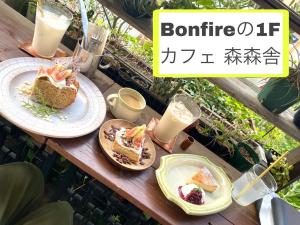 uma mesa com dois pratos de comida e bebidas em Bonfire Hostel Osaka em Osaka