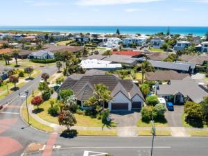 een luchtzicht op een buitenwijk met huizen en de oceaan bij Palm Paradise in Tauranga