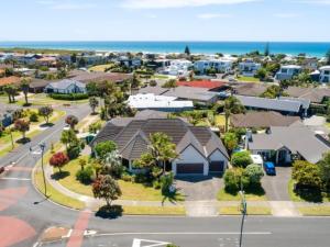an aerial view of a suburb with houses and the ocean at Palm Paradise in Tauranga