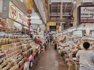 a woman walking through a grocery store aisle at Canary House Rachawong คานารี่ เฮ้าส์ ราชวงศ์ in Chiang Mai
