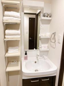 a bathroom with a sink and a mirror and towels at KOHALA　HOTEL in Naha