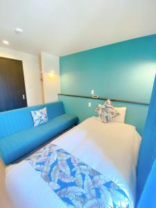 a blue room with a bed and a couch at KOHALA　HOTEL in Naha