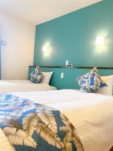a bedroom with two beds with blue walls at KOHALA　HOTEL in Naha