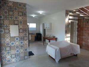 a room with a bed and a wall with tiles at Casa com Vista do Mar e Montanha in Peruíbe