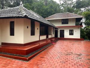 a building with a red brick courtyard in front of it at Deesha Homes in Wayanad