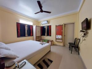 a bedroom with a bed and a ceiling fan at Mira International in Digha