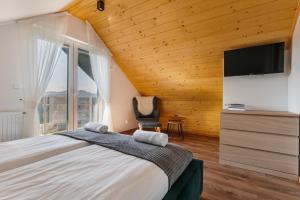 a bedroom with a large bed and a tv at Domek nad zalewem in Czorsztyn