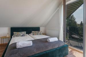 a bedroom with a bed and a large window at Domek nad zalewem in Czorsztyn