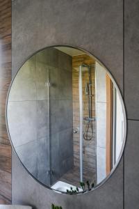 a round mirror in a bathroom with a shower at Domek nad zalewem in Czorsztyn