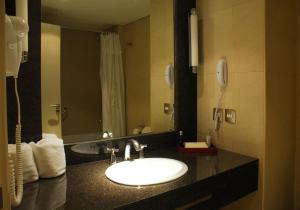 
a bathroom with a sink and a mirror at Howard Johnson Plaza Resort & Casino Mayorazgo in Paraná
