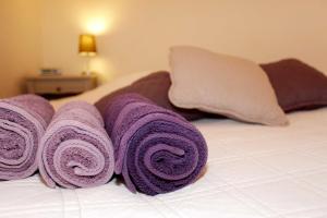 a pile of purple towels on top of a bed at La Tourrette in Tourrettes-sur-Loup