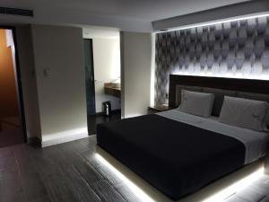 Motel Nuevo Tijuana في مدينة ميكسيكو: غرفة نوم بسرير كبير مع اللوح الأمامي كبير