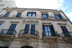 a tall building with windows and balconies on it at B&B La Vetreria Almarù in Catania