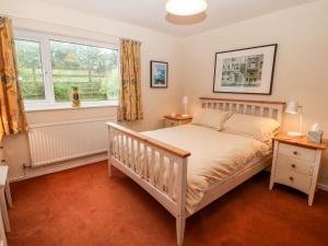 a bedroom with a crib and a window at Hefo'r Grug in Pwllheli