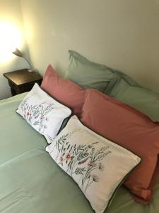 a bed with three pillows on top of it at Le Rameau in Sainte-Menehould