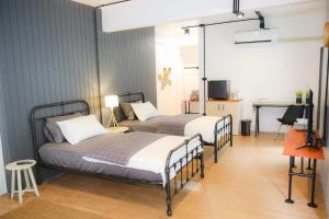 a bedroom with two beds and a television in it at SLEEP SLEEP SUANPHAK in Ban Khlong Bang Sai